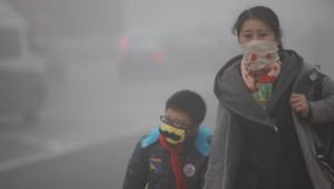 CHANGCHUN, CHINA - OCTOBER 21: (CHINA OUT) A woman and her son wearing masks walk along a road as heavy smog engulfs the city on October 21, 2013 in Changchun, China. Expressways, schools and an airport remain closed as heavy smog continues to disrupt northeast China. (Photo by ChinaFotoPress/Getty Images)
